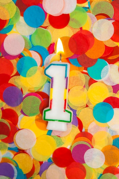 Celebration candle number 1 on a confetti background