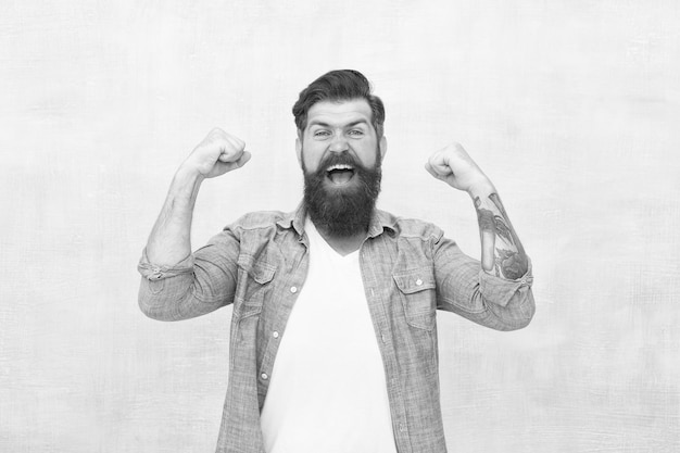 Celebration concept Bearded man trendy hipster style Cheerful mood Happiness and joy Hipster with beard and mustache happy expression Brutal handsome hipster man on grey wall background