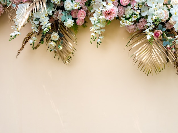 Photo celebration decoration with gold tropical palm leaves with white and pink roses flower bouquet.