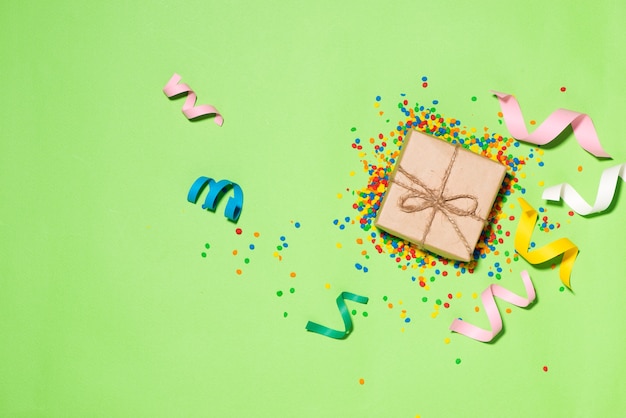 Celebration Flat lay. Gift box with colorful party items on green background.