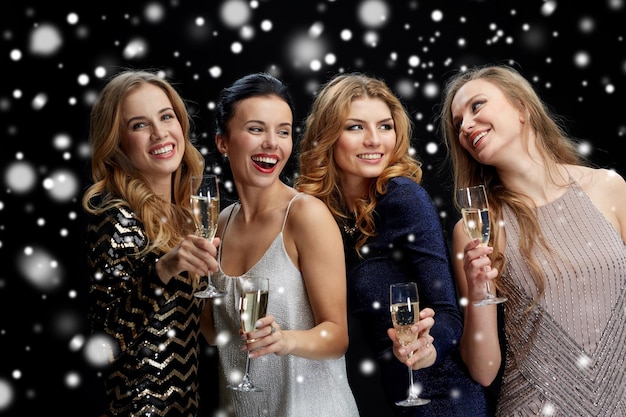 celebration, friends, bachelorette party and holidays concept - happy women with champagne glasses over black background