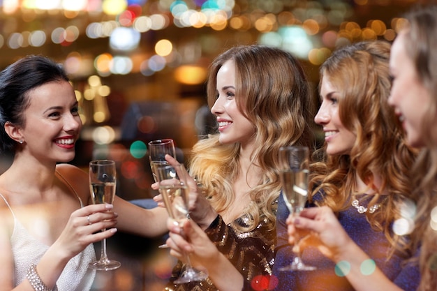 celebration, friends, bachelorette party and holidays concept - happy women with champagne glasses at night club