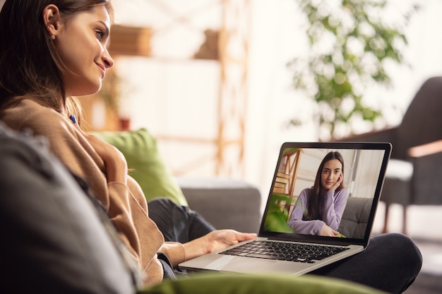 Celebration and holidays during quarantine concept. Friends or family unpacking gifts while talking using video call. Look happy, cheerful, sincere. Concept of New Year, technologies, emotions.