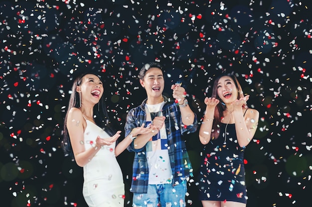 Celebration party group of asian young people holding confetti