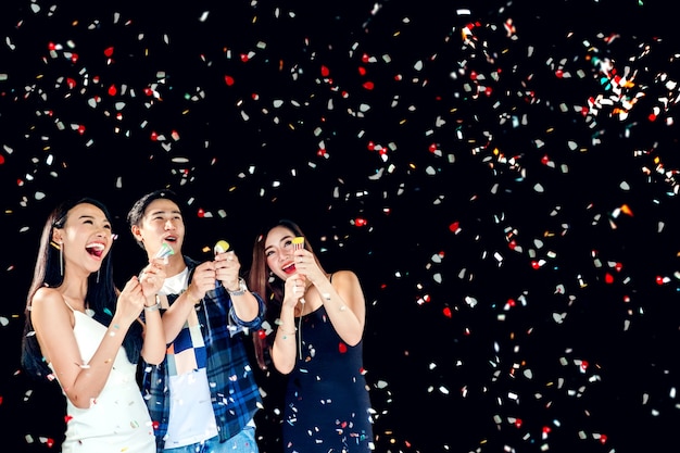 Celebration party group of asian young people holding confetti