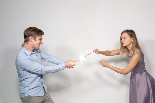 Celebration party and holiday concept  portrait of young couple fooling around with sparklers