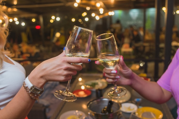 Celebration. People holding glasses of white wine making a toast.