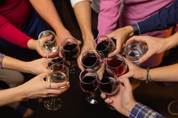 Celebration people holding glasses of white wine making a toast