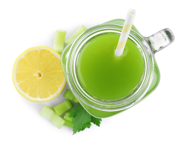 Celery juice in mason jar and fresh ingredients on white background top view