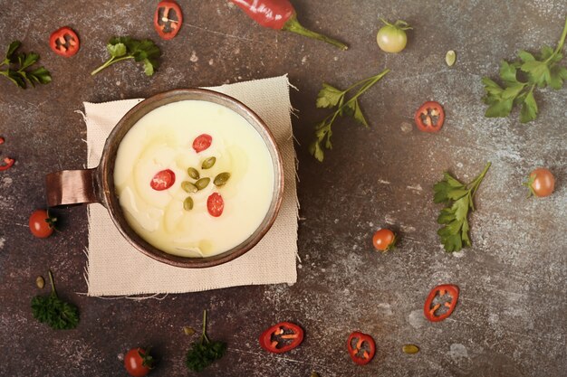 Celery root soup in copper cup on dark