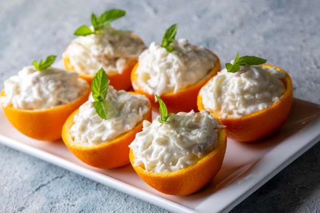 Celery salad with apple and walnuts served in orange cups.