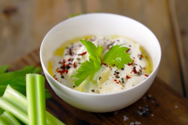 Celery sticks with white sauce in a bowl Healthy food