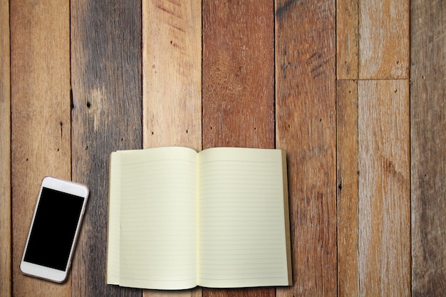 Cell phone and book on wood