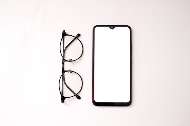 сотовый телефон и очки на белом фоне