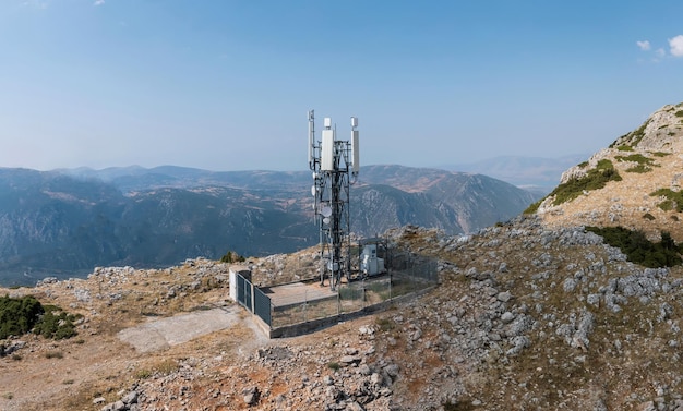 Torre cellulare antenna per telefoni cellulari vista aerea montagne rocciose e cielo blu