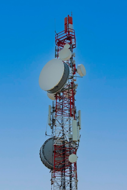 Cell tower with antenna against blue sky