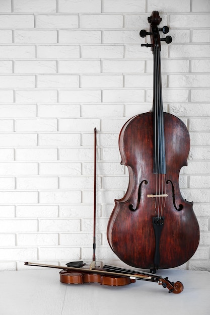 Cello and violin on bricks wall background