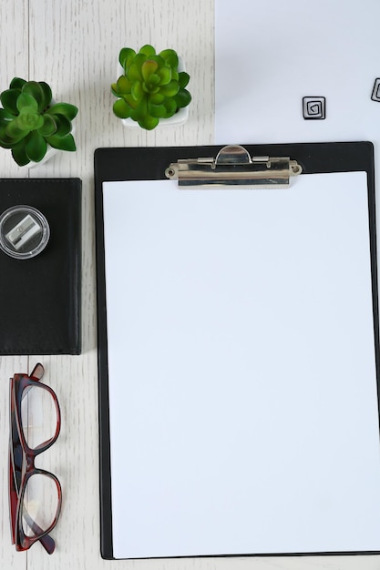 Cellphone with papers and stationery on white table