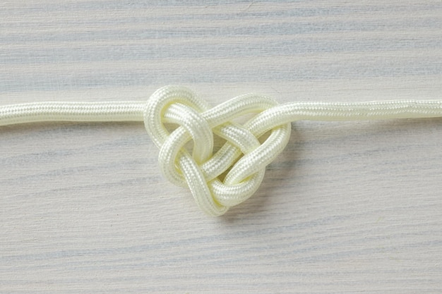 Celtic knot in the shape of a heart made of white cord Concept of creative unity faith and protection