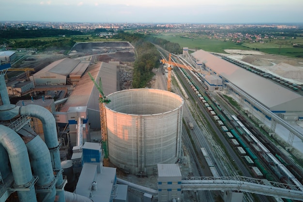 Cement plant with high factory structure and tower cranes at industrial production area Manufacture global industry and air pollution concept