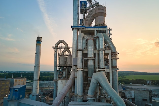 Cement plant with high factory structure and tower cranes at industrial production area Manufacture global industry and air pollution concept