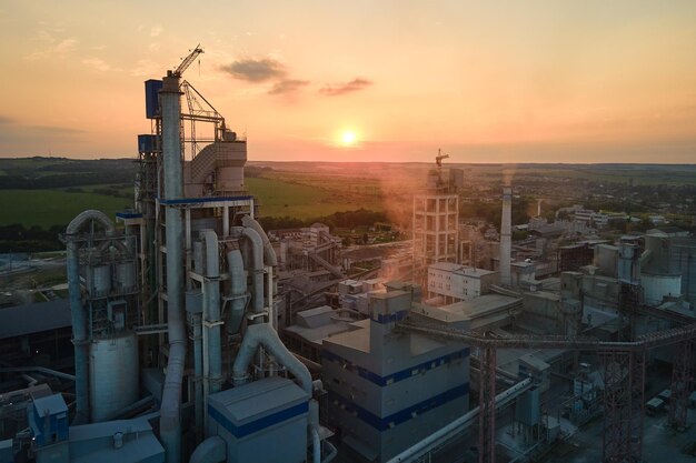 Cement plant with high factory structure and tower cranes at industrial production area Manufacture and global industry concept