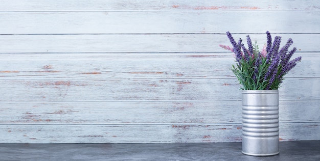 Photo cement table with purple flower on pot.