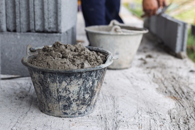 Cement tank and scoop into brick blocks in construction area