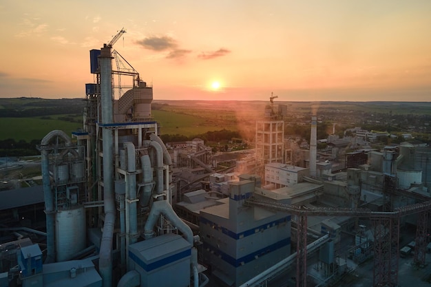 Cementfabriek met hoge fabrieksstructuur en torenkranen op industrieel productiegebied Fabricage en wereldwijd industrieconcept