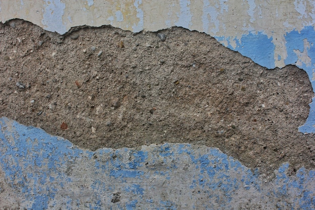 Cementtextuur op gebarsten muurachtergrond met het pellen van blauwe verf