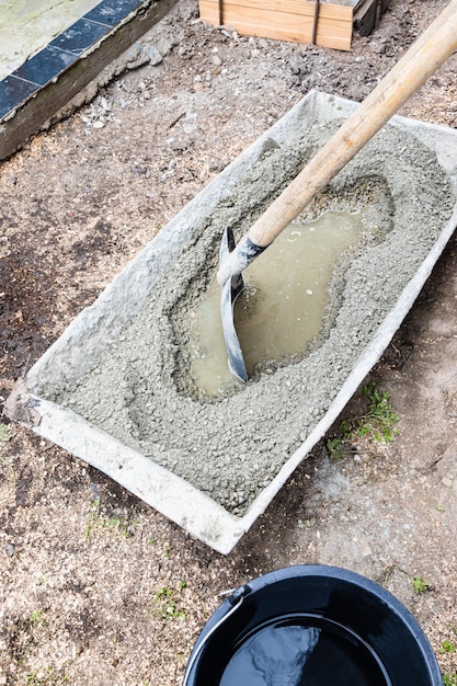 Cementzand en grind mengen zich buiten in de trog