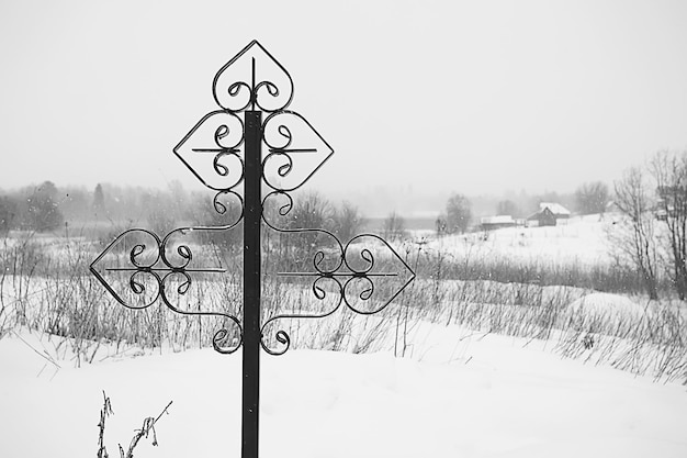 Croce invernale del cimitero / concetto di solitudine dolore, croce nel paesaggio invernale