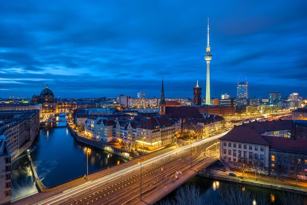 The center of berlin with the famous tv tower and a clouded sky at night