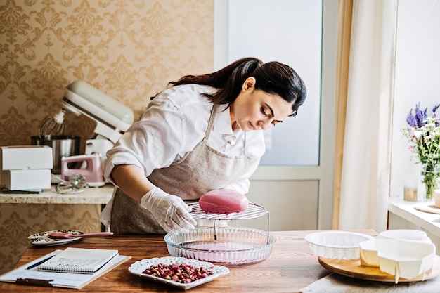 Photo central asian arabic woman pastry chef making mirror glaze mousse cake female middle east