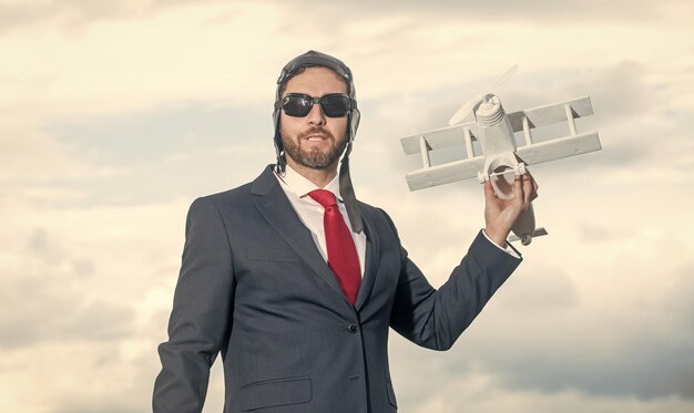 Ceo in suit and pilot hat launch plane toy