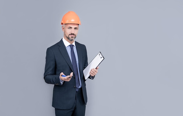 Ceo with construction documents mature boss with clipboard confident businessman in helmet hold folder safety business expertise successful man in hardhat making notes entrepreneur hold project