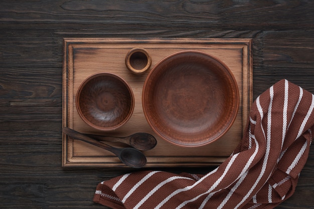 Ceramic bowl and kitchen utensils on cutting board