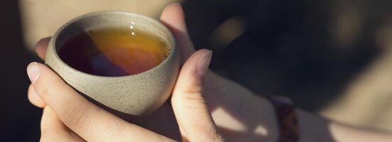 Ceramic bowls made of clay on a wooden background. 
the girl is drinking chinese tea.