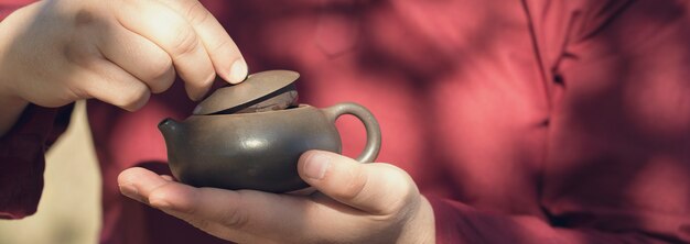 Ceramic bowls made of clay on a wooden background. 
The man is drinking Chinese tea.