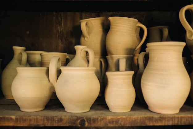 Ceramic clay jugs standing on a shelf in the village