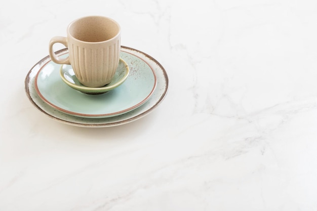 Ceramic cup and plate on white marble table