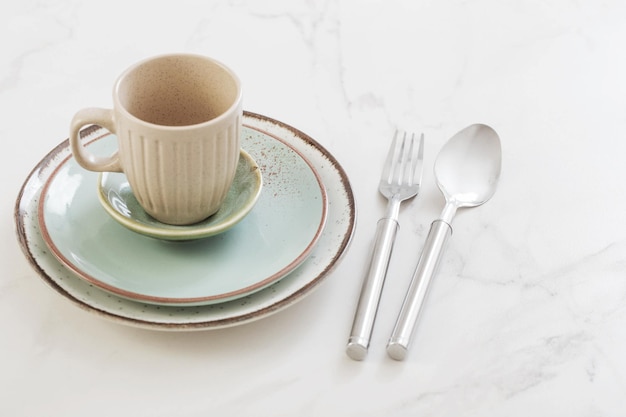 Ceramic cup and plate on white marble table