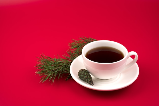 Ceramic cup with hot coffee and pine branch