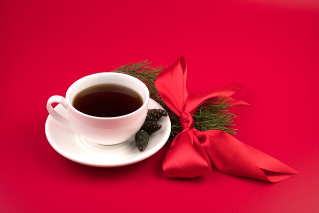 Ceramic cup with hot coffee and pine branch