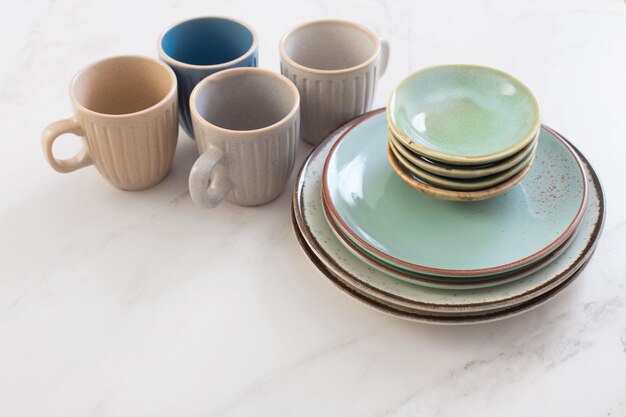 Ceramic cups and plates on white marble table