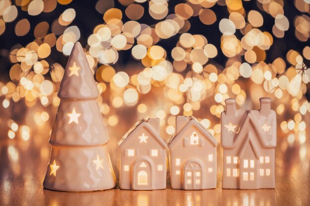 Foto casa in ceramica e albero di natale su sfondo chiaro maculato