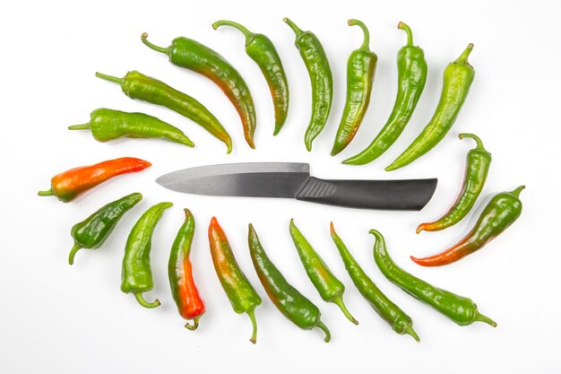 Ceramic knife and green hot peppers on a white background. cooking vegetables for food