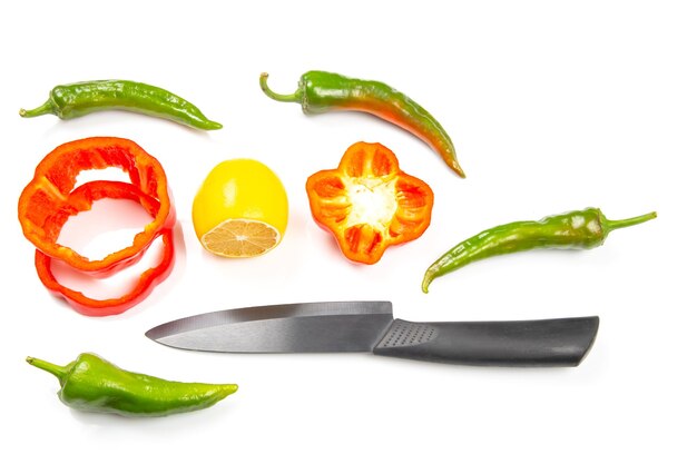 Ceramic knife and green hot peppers on a white background cooking vegetables for food