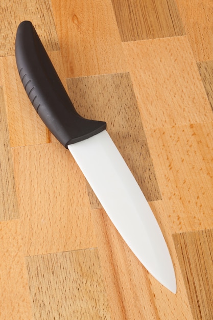 Ceramic knife on wooden cutting board 