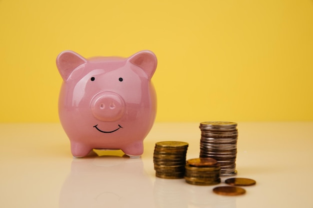Ceramic piggy bank with stack of coins closeup Savings concept